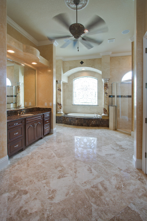 Cette image montre une salle de bain principale de taille moyenne avec un carrelage beige, un carrelage de pierre et un sol en marbre.