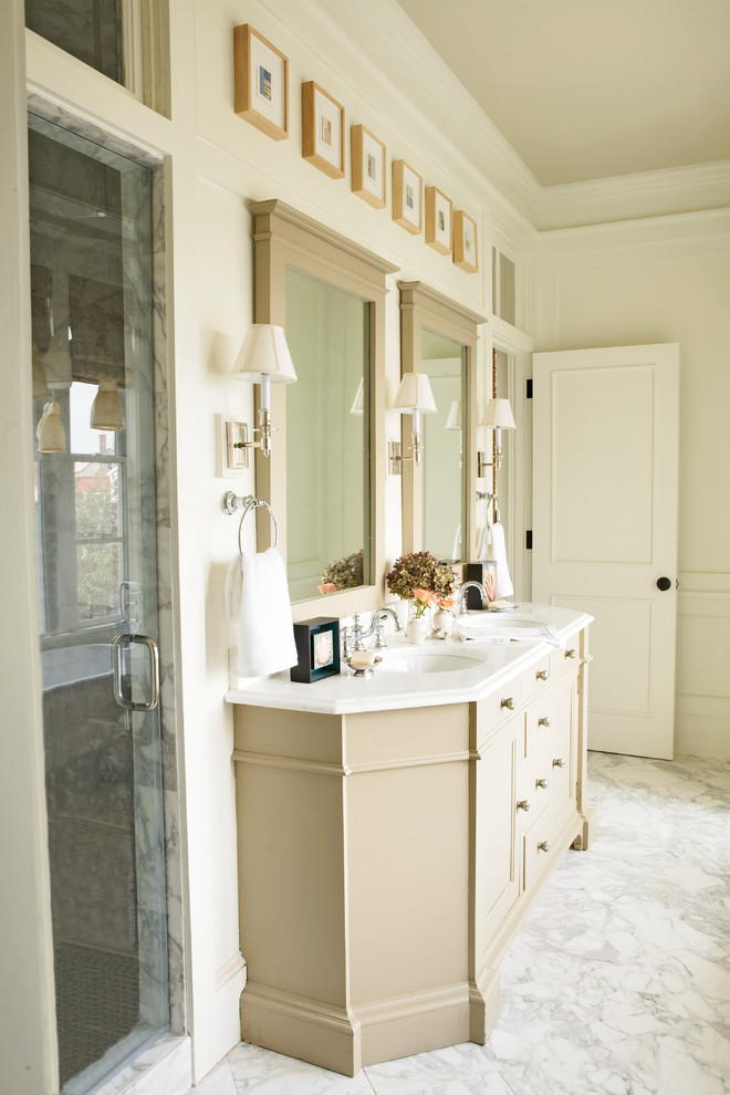 Klassisches Badezimmer mit Unterbauwaschbecken, beigen Schränken, Marmor-Waschbecken/Waschtisch, Duschnische, weißer Wandfarbe und Marmorboden in Atlanta