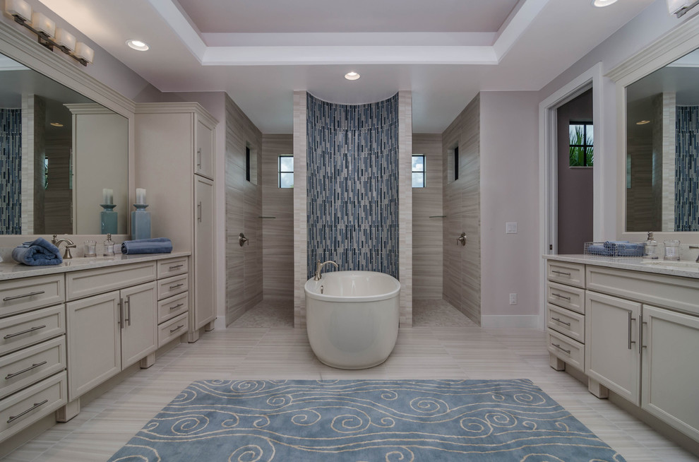 Beach style gray tile and porcelain tile porcelain tile bathroom photo in Miami with recessed-panel cabinets, white cabinets, a two-piece toilet, an undermount sink and quartzite countertops