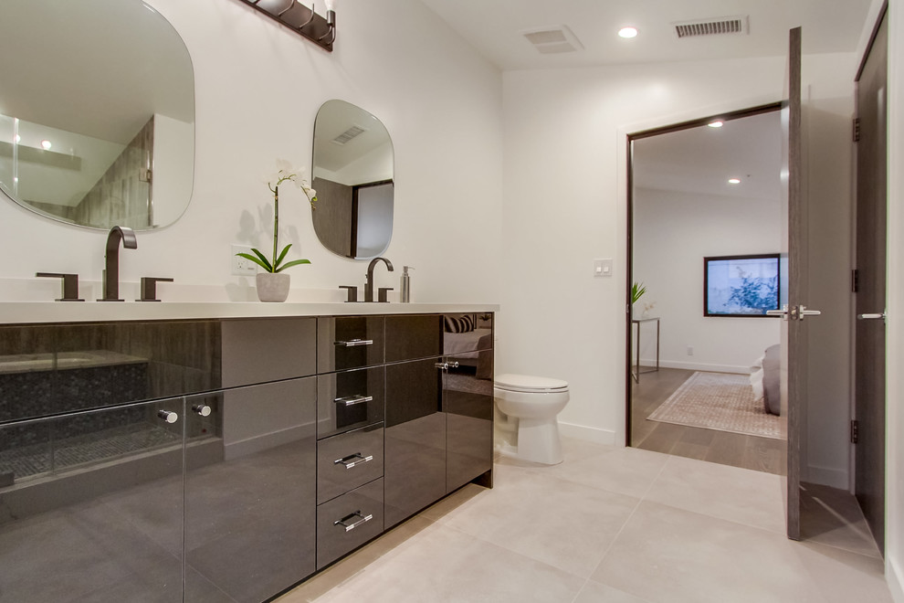 Inspiration for a mid-sized contemporary master cement tile floor and gray floor alcove shower remodel in Los Angeles with flat-panel cabinets, black cabinets, an undermount tub, a one-piece toilet, white walls, an undermount sink, solid surface countertops and a hinged shower door