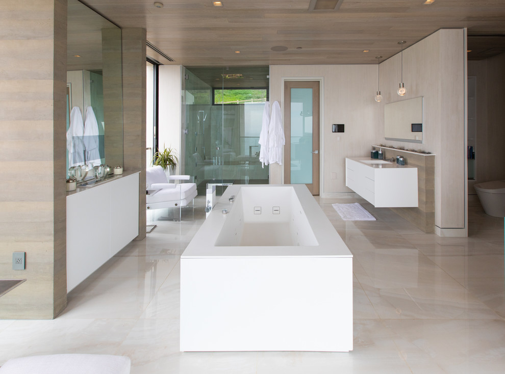 Trendy master beige tile beige floor bathroom photo in Los Angeles with flat-panel cabinets, white cabinets, beige walls, an undermount sink, a hinged shower door and beige countertops