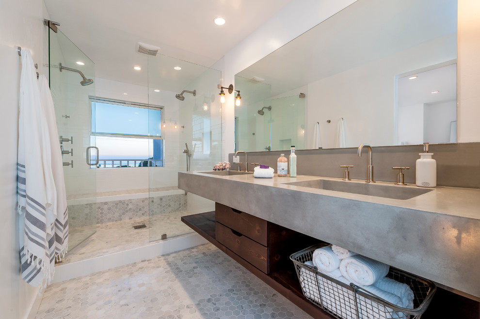 Coastal ensuite bathroom in San Diego with an integrated sink, concrete worktops, a double shower, white tiles, metro tiles, mosaic tile flooring, open cabinets, dark wood cabinets and white walls.