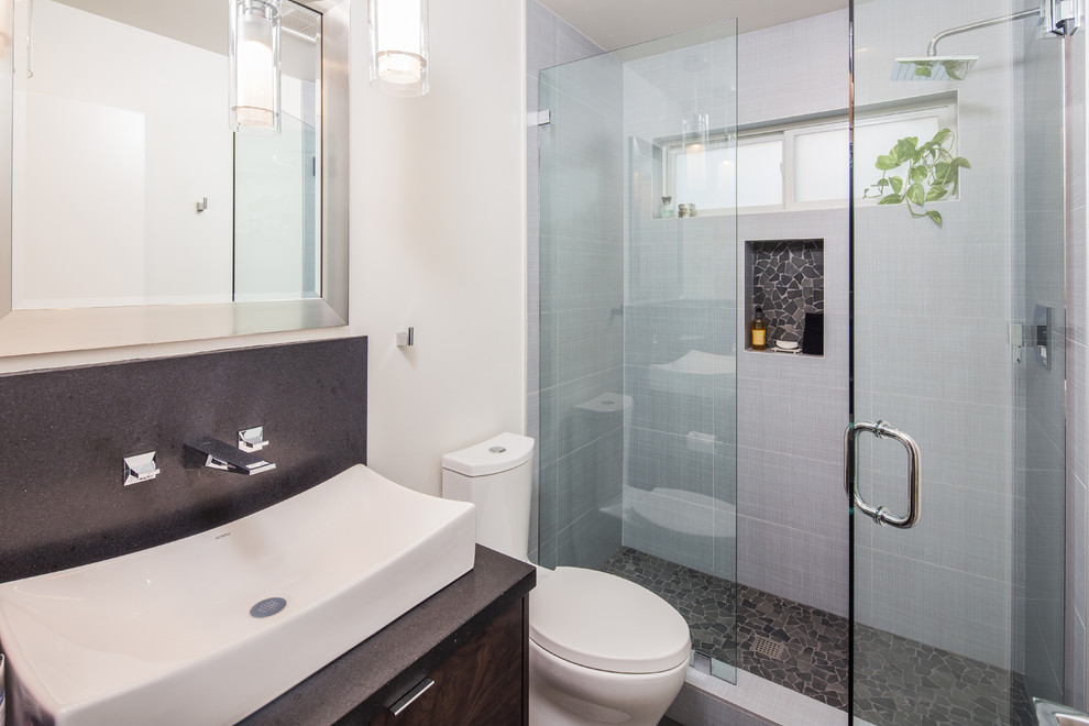 Exempel på ett litet modernt badrum, med släta luckor, skåp i ljust trä, en öppen dusch, en toalettstol med hel cisternkåpa, grå kakel, porslinskakel, vita väggar, klinkergolv i porslin och granitbänkskiva