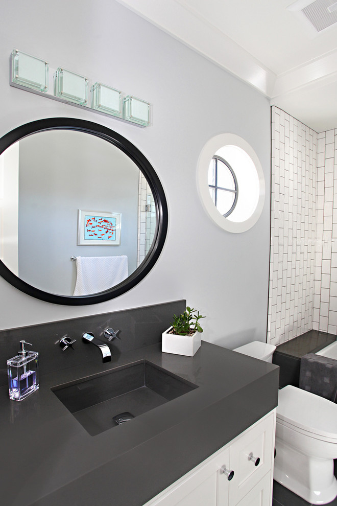 Exempel på ett modernt badrum, med ett undermonterad handfat, en dusch/badkar-kombination, en toalettstol med hel cisternkåpa, luckor med infälld panel, vita skåp, vit kakel och tunnelbanekakel