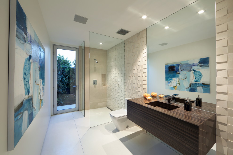 Свежая идея для дизайна: большая ванная комната в современном стиле с открытыми фасадами, коричневыми фасадами, угловым душем, унитазом-моноблоком, бежевой плиткой, каменной плиткой, бежевыми стенами, полом из керамической плитки, душевой кабиной, монолитной раковиной, столешницей из ламината, белым полом и открытым душем - отличное фото интерьера