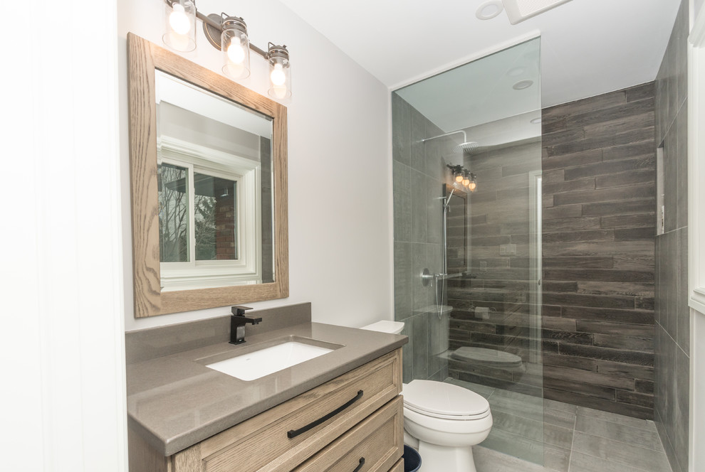 Design ideas for a medium sized classic bathroom in Toronto with shaker cabinets, brown cabinets, a built-in shower, a two-piece toilet, brown tiles, porcelain tiles, grey walls, porcelain flooring, a submerged sink, engineered stone worktops, grey floors, an open shower and grey worktops.