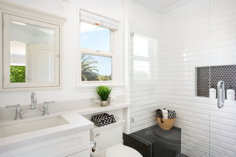 Small trendy master white tile and subway tile porcelain tile and white floor bathroom photo in Tampa with shaker cabinets, white cabinets, a one-piece toilet, white walls, an undermount sink, quartz countertops, a hinged shower door and white countertops