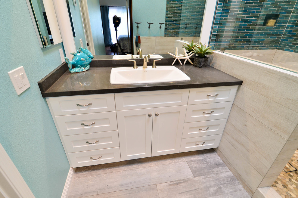 Medium sized nautical ensuite bathroom in Tampa with a built-in sink, shaker cabinets, white cabinets, engineered stone worktops, a walk-in shower, blue tiles, glass tiles, blue walls and porcelain flooring.