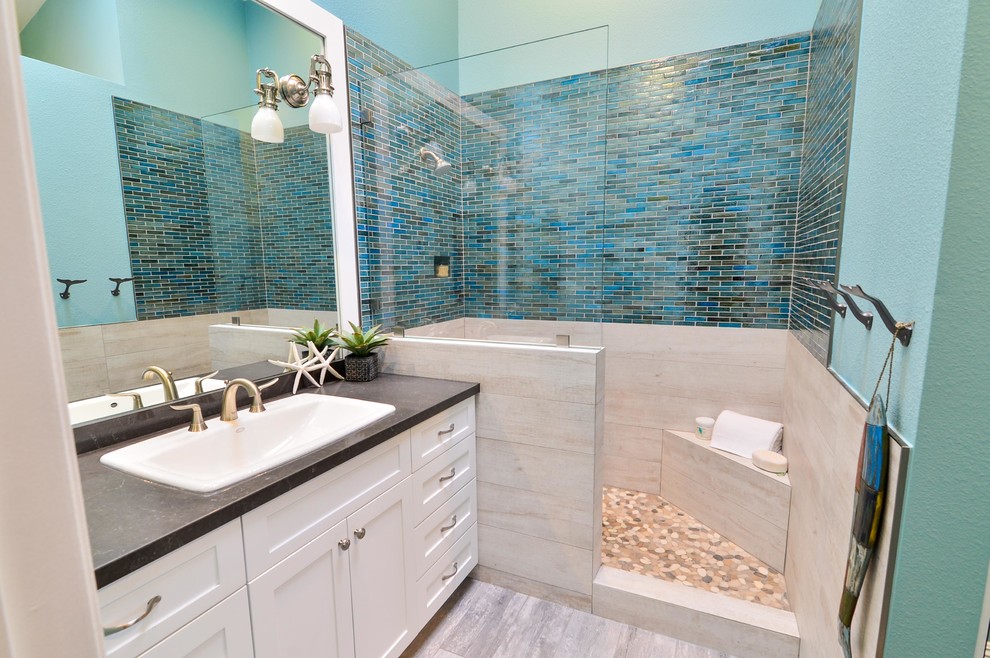 На фото: главная ванная комната среднего размера в морском стиле с накладной раковиной, фасадами в стиле шейкер, белыми фасадами, столешницей из искусственного кварца, открытым душем, синей плиткой, стеклянной плиткой, синими стенами и полом из керамогранита с