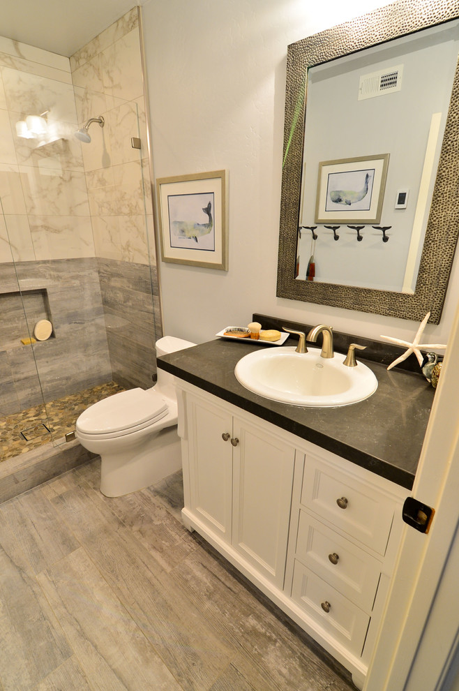 Inspiration for a medium sized beach style bathroom in Tampa with a built-in sink, shaker cabinets, white cabinets, engineered stone worktops, a walk-in shower, a one-piece toilet, grey tiles, porcelain tiles, grey walls and porcelain flooring.