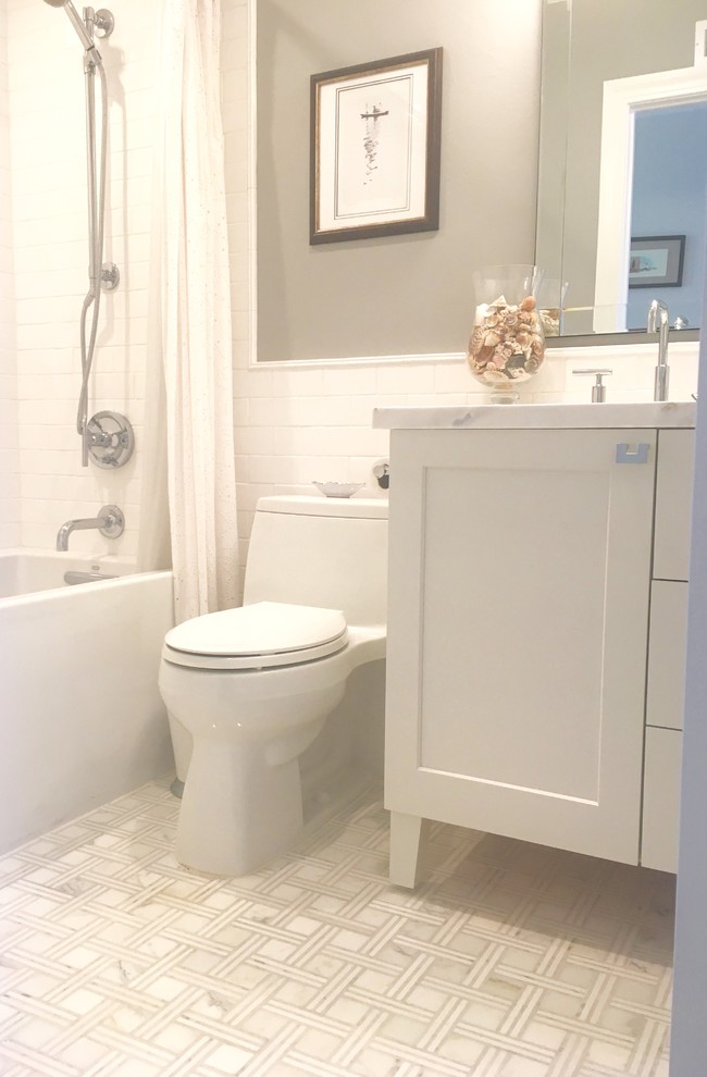 Bild på ett litet vintage vit vitt badrum för barn, med skåp i shakerstil, vita skåp, ett badkar i en alkov, en dusch i en alkov, vit kakel, tunnelbanekakel, grå väggar, marmorgolv, ett undermonterad handfat, marmorbänkskiva, grått golv och dusch med duschdraperi
