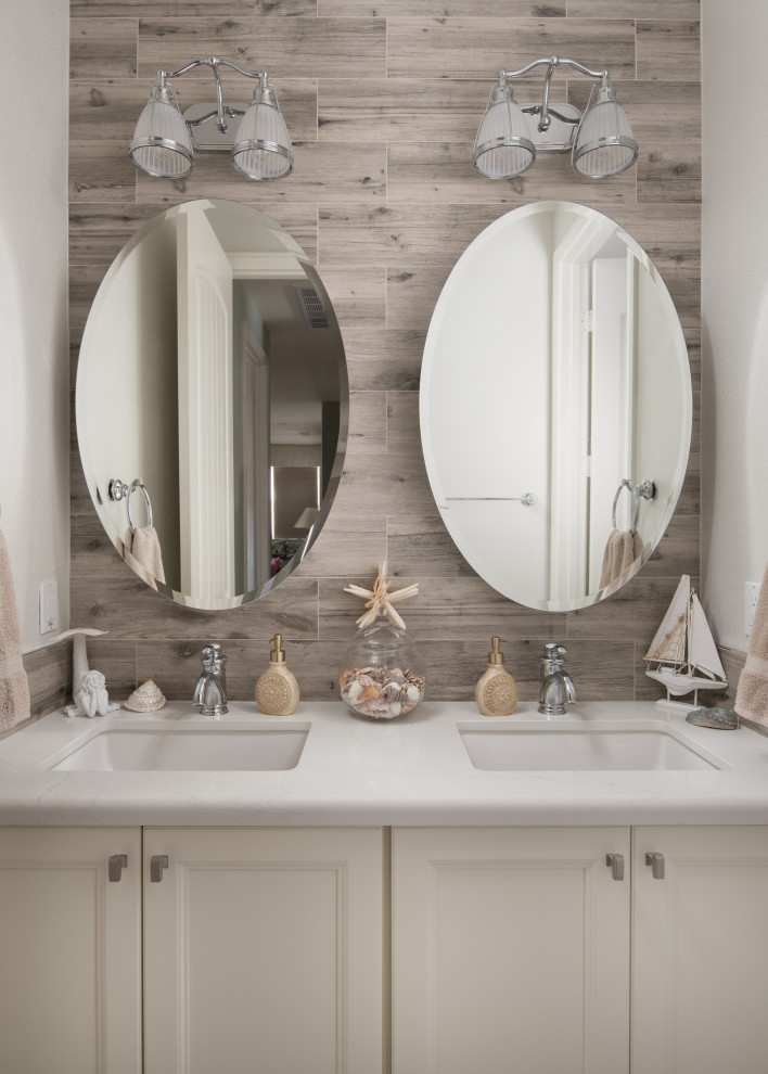 Bathroom - small coastal kids' porcelain tile pebble tile floor and beige floor bathroom idea in San Diego with recessed-panel cabinets, white cabinets, a two-piece toilet, an undermount sink, quartz countertops and white countertops