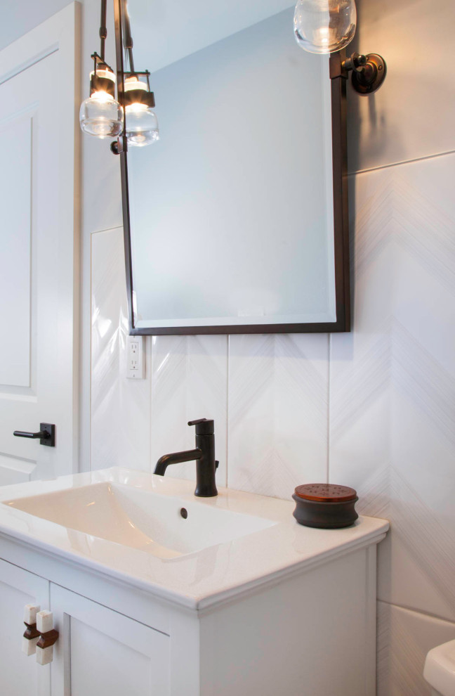 Example of a large beach style master white tile and porcelain tile vinyl floor and gray floor bathroom design in Denver with flat-panel cabinets, gray cabinets, a one-piece toilet, white walls, an undermount sink, quartz countertops, a hinged shower door and white countertops