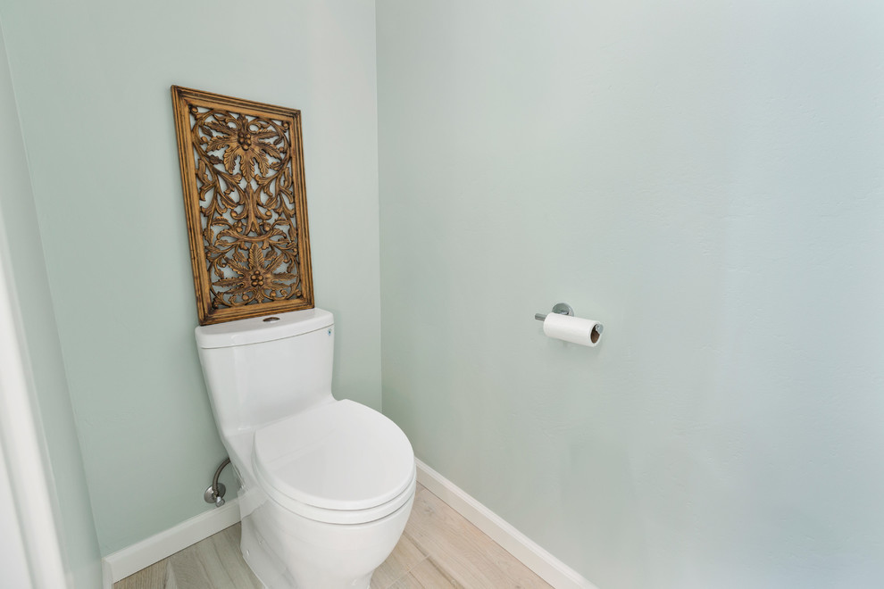 Design ideas for a large coastal cloakroom in Tampa with flat-panel cabinets, distressed cabinets, a one-piece toilet, green tiles, porcelain tiles, green walls, porcelain flooring, a submerged sink, quartz worktops, brown floors and green worktops.