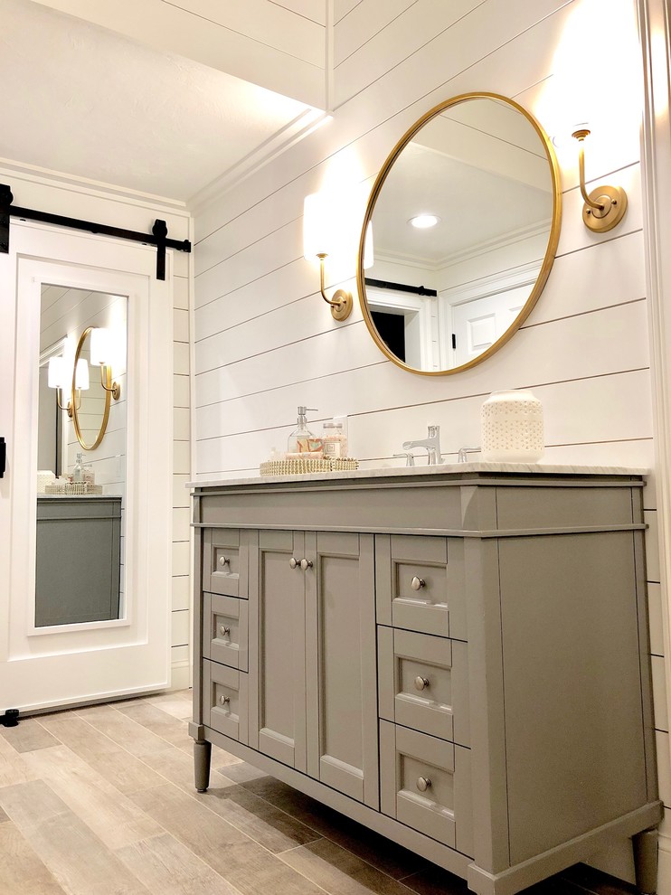 Inspiration for a large cottage master light wood floor and brown floor bathroom remodel in Bridgeport with recessed-panel cabinets, gray cabinets, white walls, an undermount sink, granite countertops and white countertops