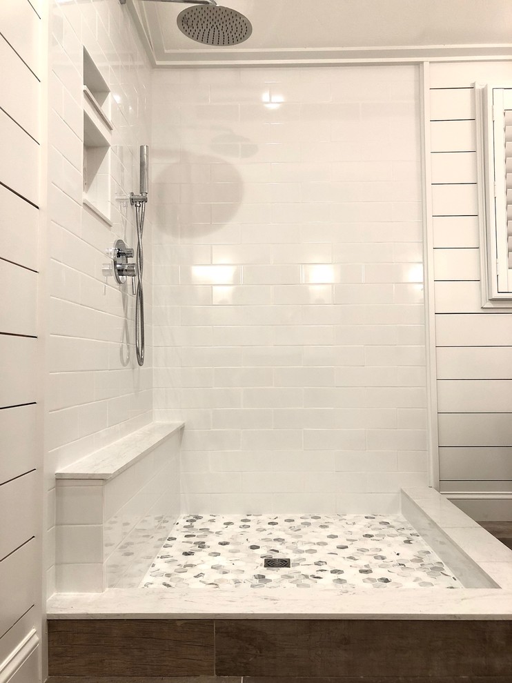 На фото: большая главная ванная комната в стиле кантри с фасадами с утопленной филенкой, серыми фасадами, отдельно стоящей ванной, угловым душем, белой плиткой, плиткой кабанчик, белыми стенами, светлым паркетным полом, врезной раковиной, столешницей из гранита, коричневым полом, открытым душем и белой столешницей с