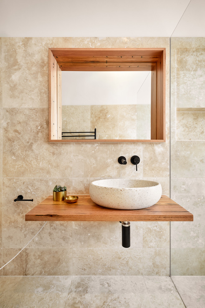Inspiration för små moderna brunt badrum med dusch, med luckor med glaspanel, bruna skåp, ett fristående badkar, en öppen dusch, beige kakel, ett fristående handfat, träbänkskiva och med dusch som är öppen