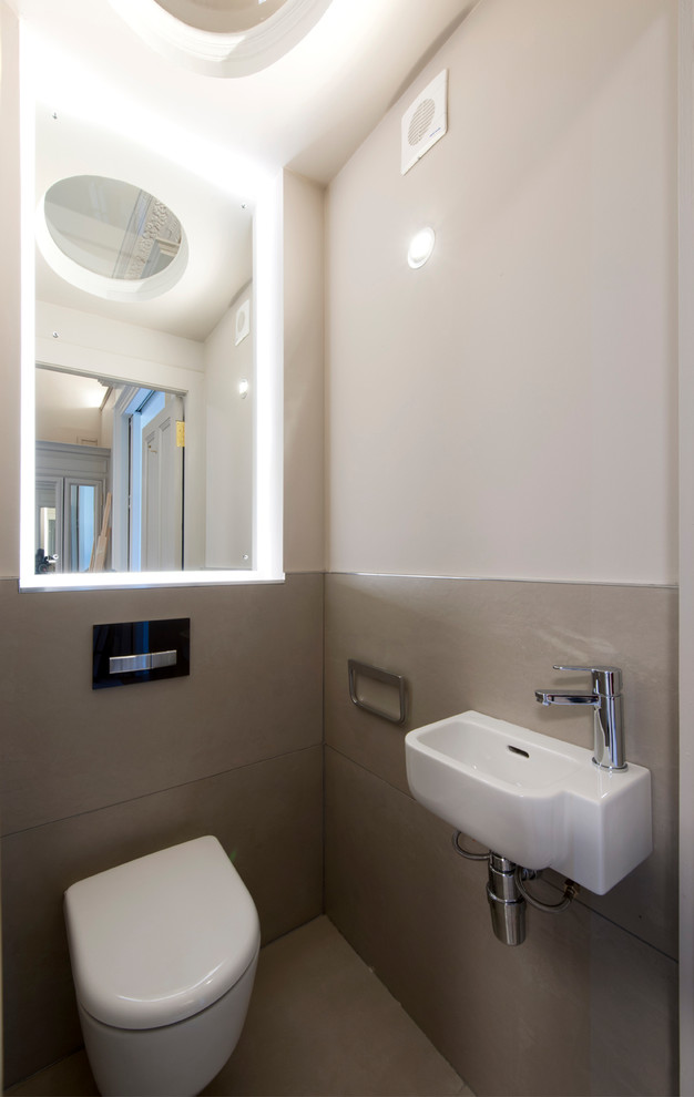 Immagine di un grande bagno di servizio design con WC sospeso, piastrelle beige, piastrelle in gres porcellanato, pareti beige, pavimento in gres porcellanato e pavimento beige
