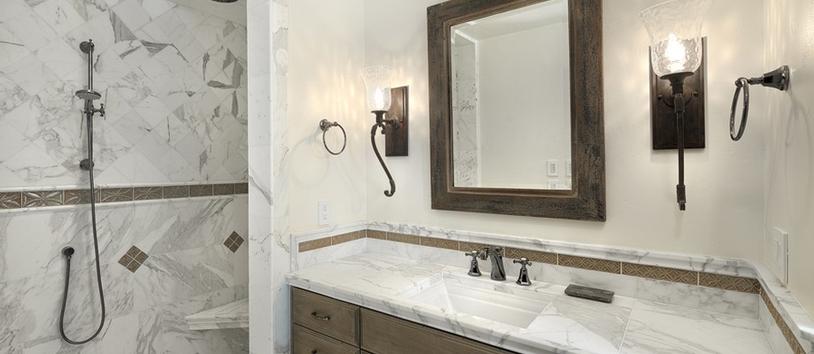 Cette image montre une salle de bain principale traditionnelle en bois clair avec un plan de toilette en marbre et un mur blanc.