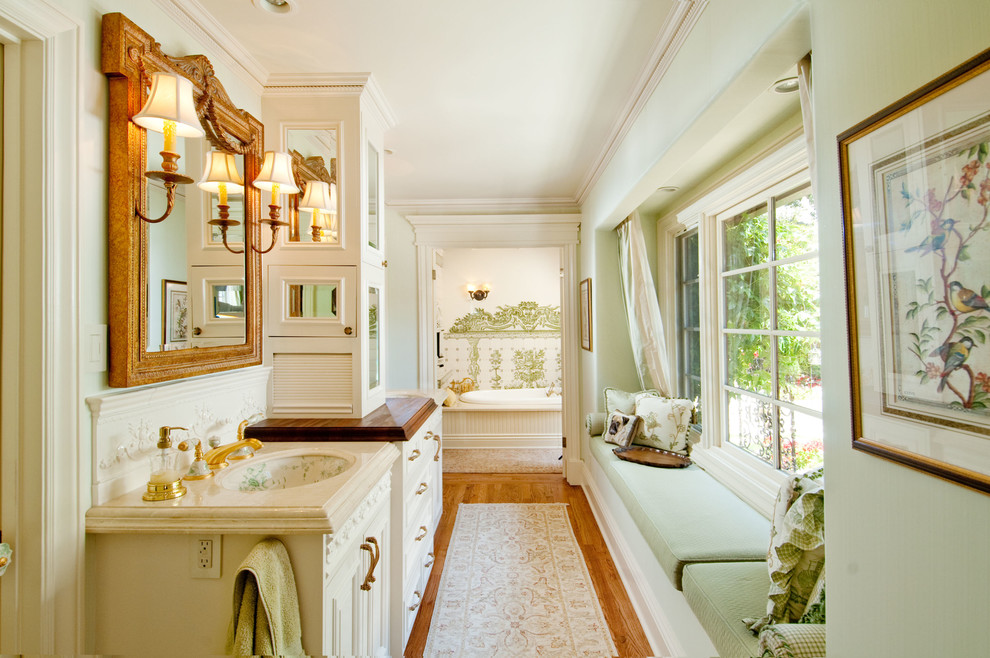 Modelo de cuarto de baño principal clásico con lavabo bajoencimera, puertas de armario beige y paredes verdes