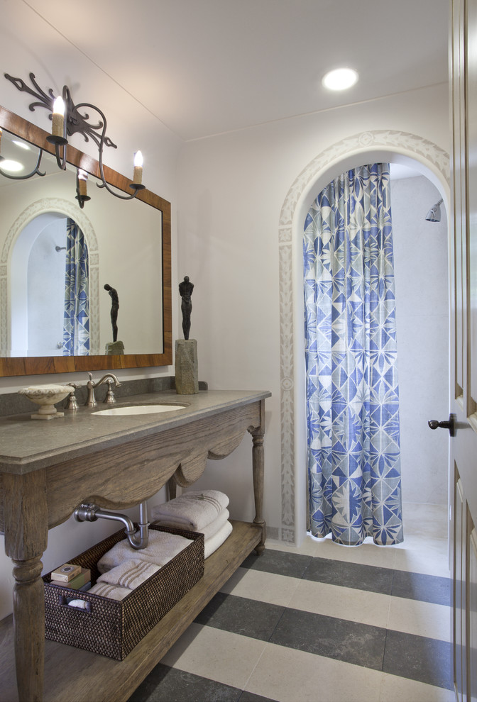Inredning av ett medelhavsstil mellanstort badrum med dusch, med grå skåp, en dusch i en alkov, en toalettstol med separat cisternkåpa, vita väggar, ett undermonterad handfat, träbänkskiva, öppna hyllor, klinkergolv i keramik, flerfärgat golv och dusch med duschdraperi