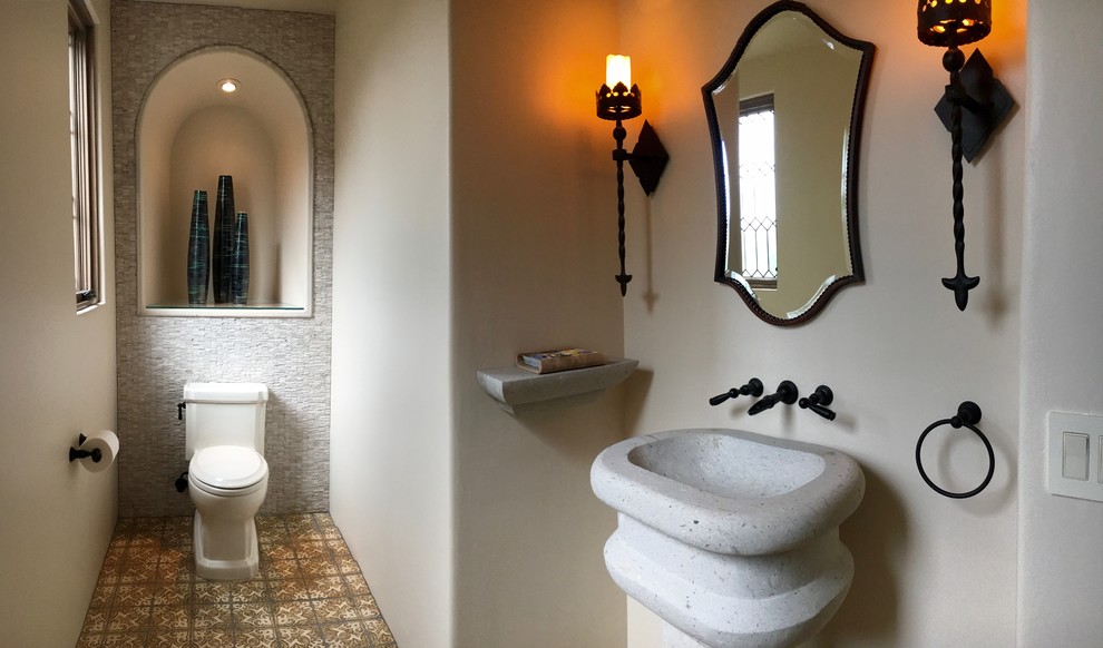 Immagine di una piccola stanza da bagno con doccia mediterranea con WC a due pezzi, piastrelle grigie, pareti bianche, pavimento con piastrelle in ceramica e lavabo a colonna