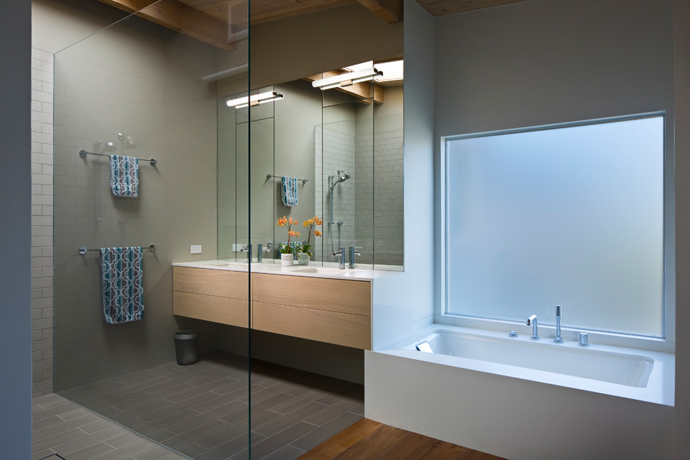 Inredning av ett modernt stort en-suite badrum, med släta luckor, skåp i ljust trä, ett undermonterat badkar, en öppen dusch, vit kakel, tunnelbanekakel, bruna väggar, mellanmörkt trägolv, ett integrerad handfat, bänkskiva i kvarts, brunt golv och med dusch som är öppen