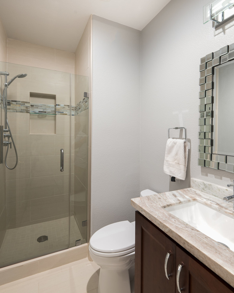 Cette photo montre une salle de bain moderne en bois brun de taille moyenne avec un placard à porte plane, WC séparés, un carrelage beige, des carreaux de porcelaine, un mur gris, un sol en carrelage de porcelaine, un lavabo encastré et un plan de toilette en granite.