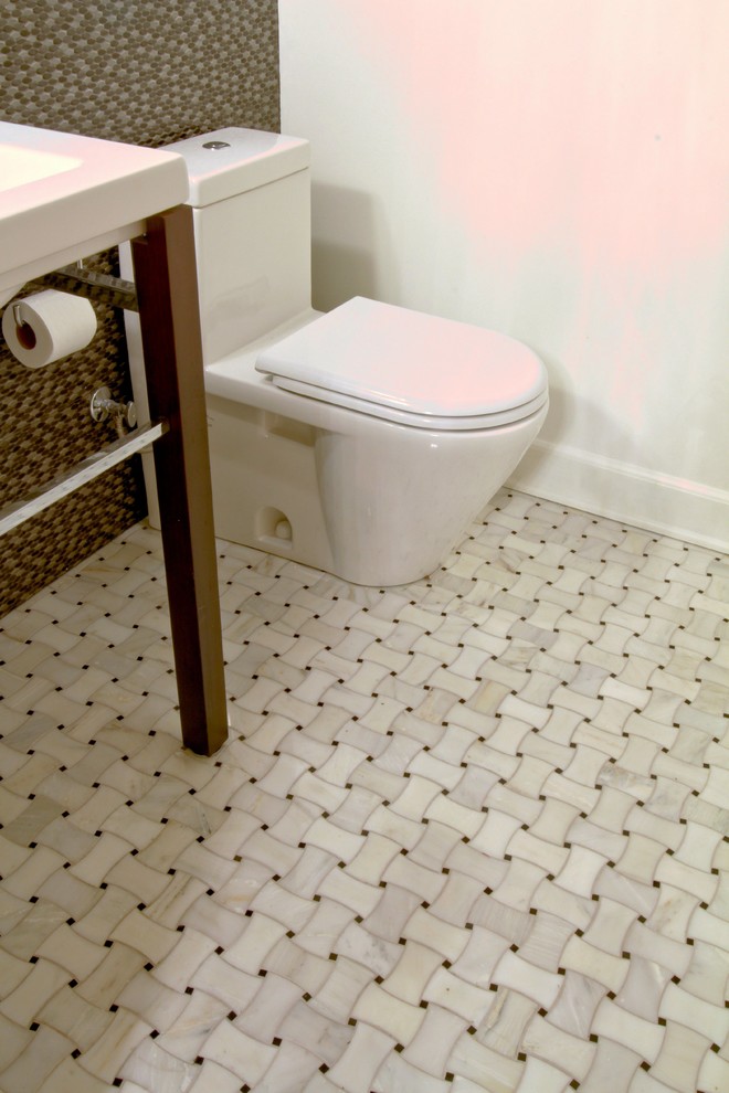 Klassisk inredning av ett badrum, med ett konsol handfat, en toalettstol med hel cisternkåpa och vit kakel