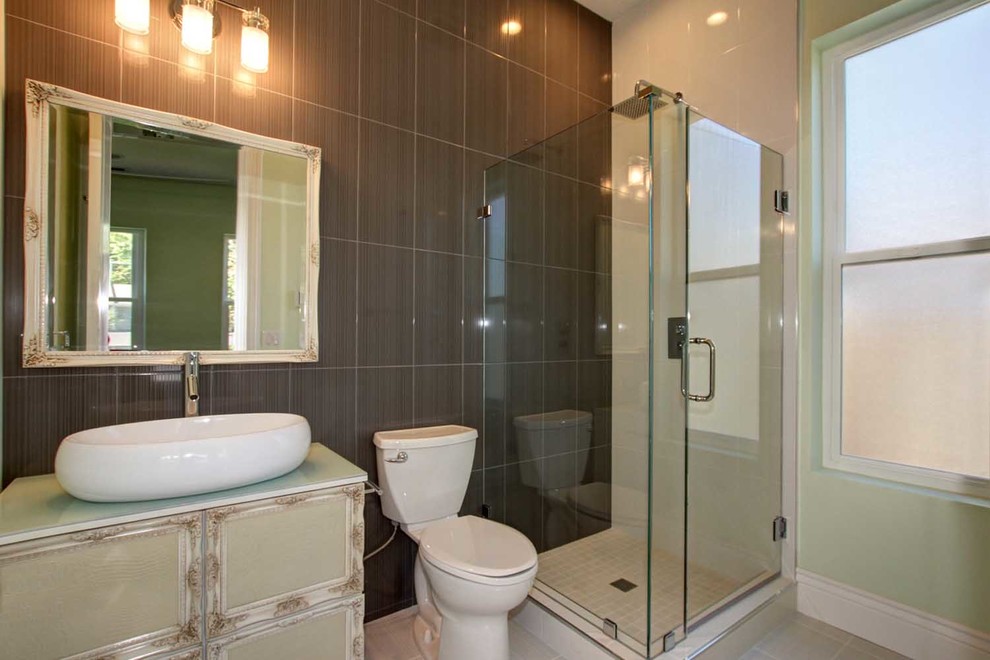 Стильный дизайн: ванная комната среднего размера в стиле модернизм с раздельным унитазом, белой плиткой, коричневой плиткой, полом из керамической плитки, фасадами островного типа, серыми фасадами, угловым душем, керамической плиткой, разноцветными стенами, душевой кабиной, настольной раковиной, стеклянной столешницей, бежевым полом и душем с распашными дверями - последний тренд