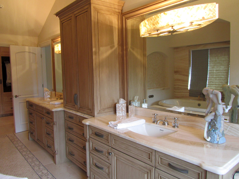 Exempel på ett stort klassiskt en-suite badrum, med luckor med upphöjd panel, skåp i slitet trä, ett fristående badkar, en dusch i en alkov, en toalettstol med hel cisternkåpa, beige kakel, porslinskakel, beige väggar, klinkergolv i porslin, ett undermonterad handfat och bänkskiva i onyx