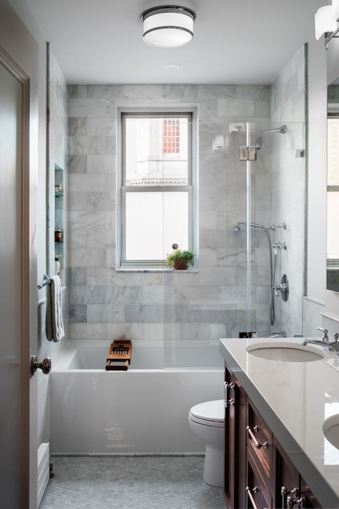 Design ideas for a classic bathroom in New York with recessed-panel cabinets, dark wood cabinets, an alcove bath, a shower/bath combination, grey tiles, white tiles, white walls, pebble tile flooring, a submerged sink, grey floors, an open shower and white worktops.
