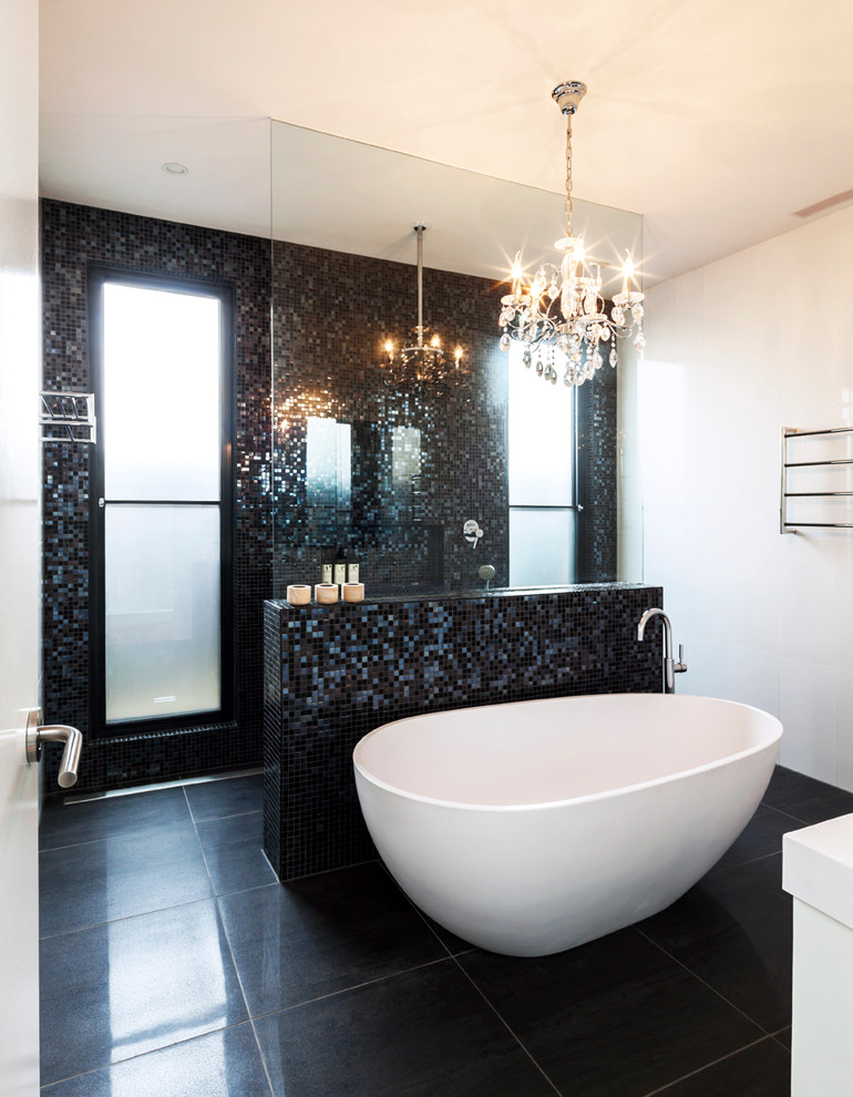 Foto på ett funkis badrum, med ett fristående badkar, mosaik, vita väggar, svart kakel och svart golv