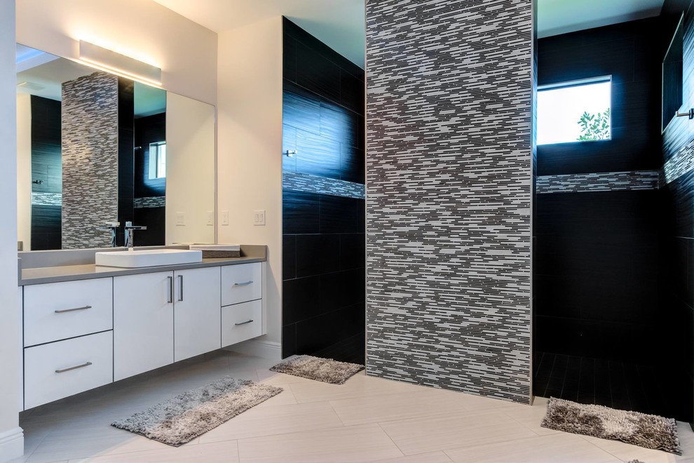 Photo of a large contemporary ensuite bathroom in Other with flat-panel cabinets, white cabinets, a walk-in shower, black and white tiles, glass tiles, grey walls, a vessel sink, engineered stone worktops, grey floors, an open shower and grey worktops.