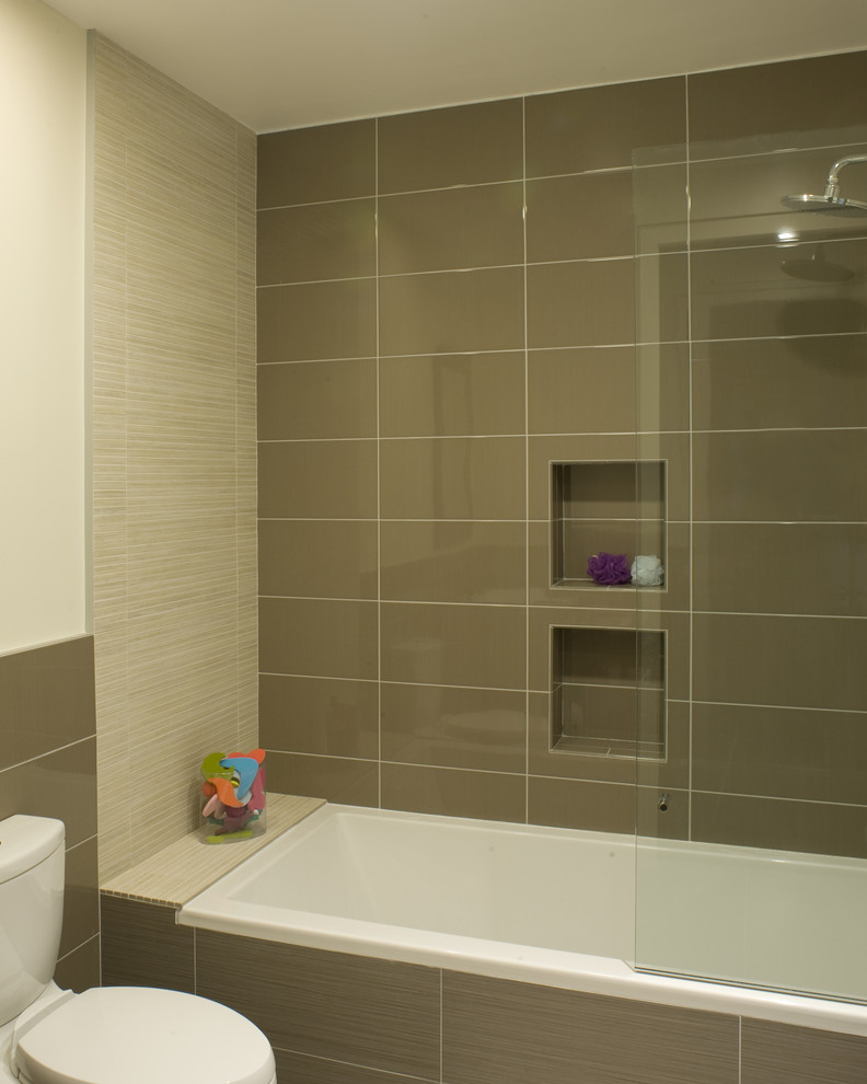 Idee per una stanza da bagno minimalista con vasca da incasso, vasca/doccia, WC a due pezzi e piastrelle marroni