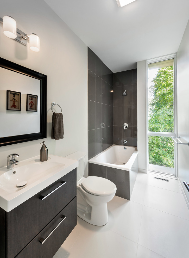 Example of a mid-sized minimalist white tile and ceramic tile ceramic tile bathroom design in Boston with an integrated sink, flat-panel cabinets, dark wood cabinets, a two-piece toilet and white walls