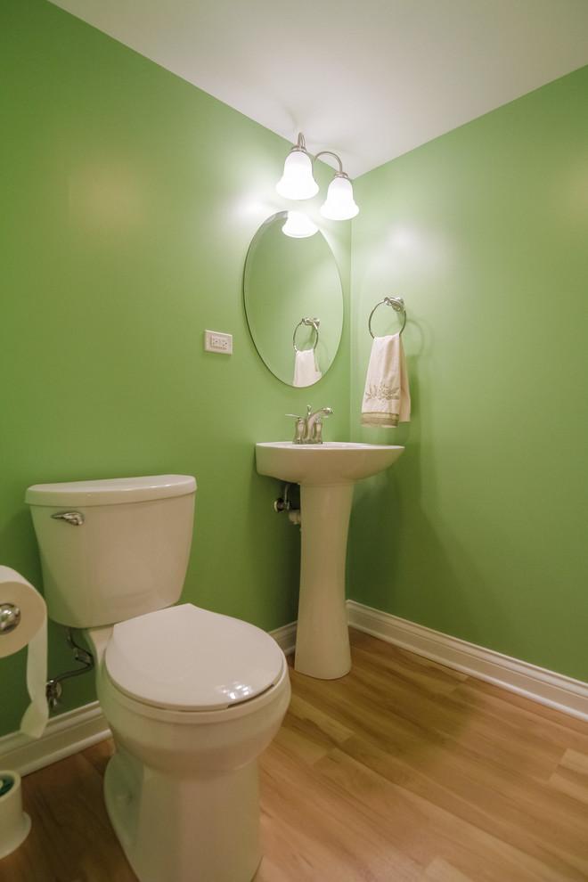 Idee per una piccola stanza da bagno con doccia moderna con lavabo a colonna, WC monopezzo, pareti verdi, parquet chiaro, ante bianche e pavimento beige