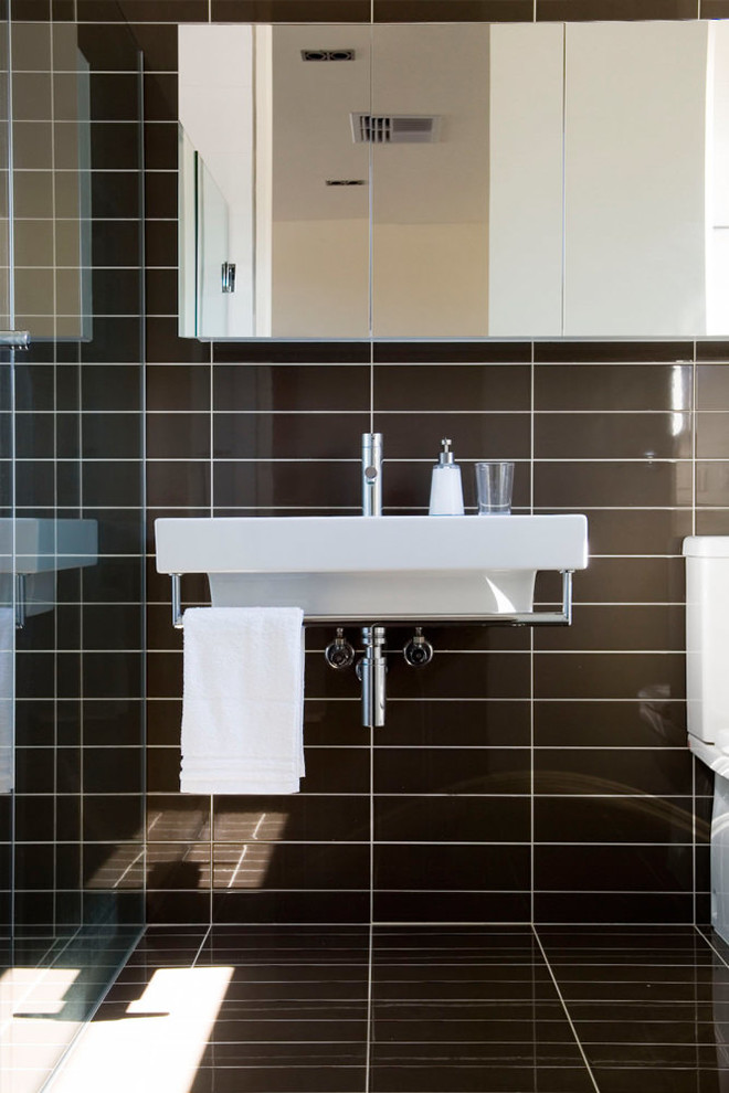 Ispirazione per una stanza da bagno contemporanea con lavabo sospeso e piastrelle marroni