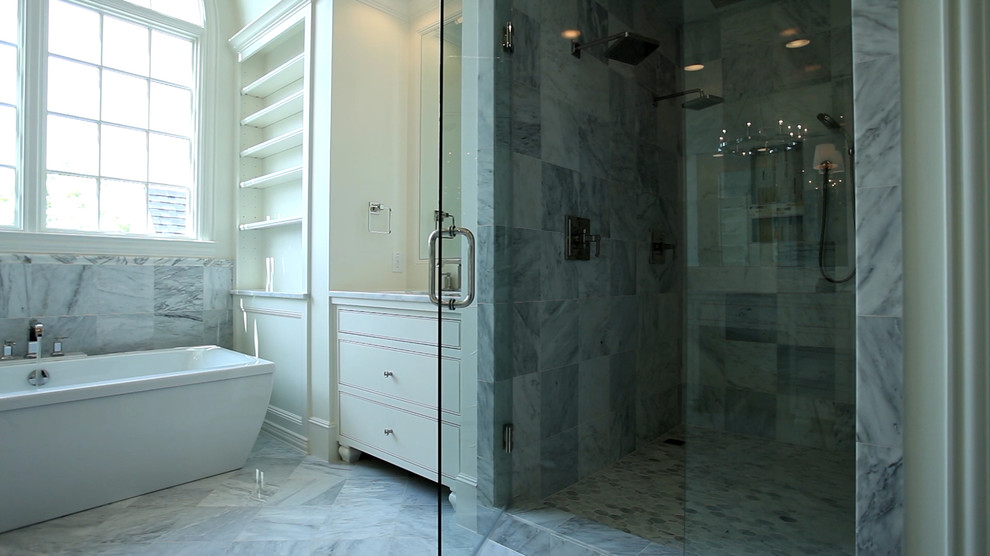 Пример оригинального дизайна: ванная комната в современном стиле с врезной раковиной, фасадами с декоративным кантом, белыми фасадами, мраморной столешницей, отдельно стоящей ванной, двойным душем, серой плиткой, каменной плиткой и мраморным полом
