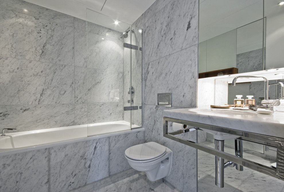На фото: ванная комната в современном стиле с ванной в нише, душем над ванной, инсталляцией и белой плиткой
