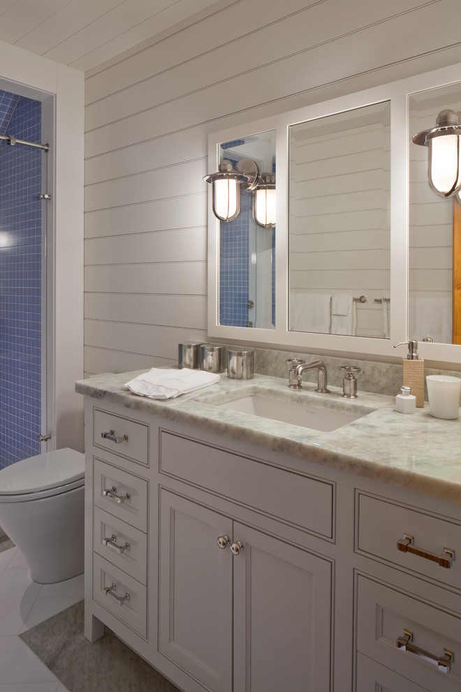 プロビデンスにある中くらいなビーチスタイルのおしゃれな浴室 (インセット扉のキャビネット、白いキャビネット、一体型トイレ	、青いタイル、白い壁) の写真