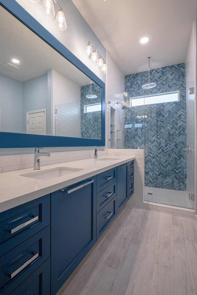 Inspiration pour une salle de bain principale design de taille moyenne avec un placard à porte shaker, des portes de placard bleues, une douche ouverte, WC séparés, un carrelage bleu, un carrelage en pâte de verre, un mur bleu, un sol en carrelage de porcelaine, un lavabo encastré, un plan de toilette en quartz modifié, un sol blanc, une cabine de douche à porte battante et un plan de toilette blanc.