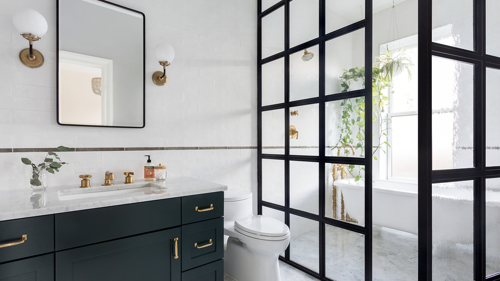 Идея дизайна: ванная комната в стиле неоклассика (современная классика) с фасадами в стиле шейкер, черными фасадами, ванной на ножках, душем без бортиков, белой плиткой, белыми стенами, врезной раковиной, серым полом, душем с распашными дверями и серой столешницей