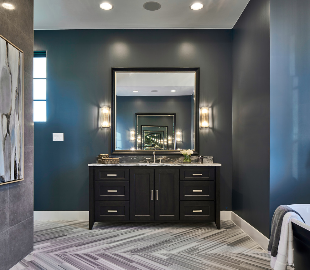 Idee per una stanza da bagno padronale minimal di medie dimensioni con ante nere, vasca freestanding, piastrelle grigie, pareti blu, pavimento in legno massello medio e pavimento beige