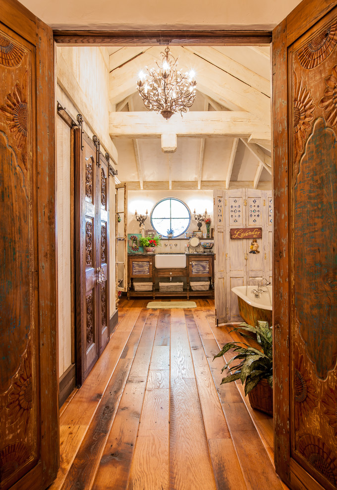 Bathroom - shabby-chic style medium tone wood floor bathroom idea in Dallas with an undermount sink, distressed cabinets, white walls and louvered cabinets