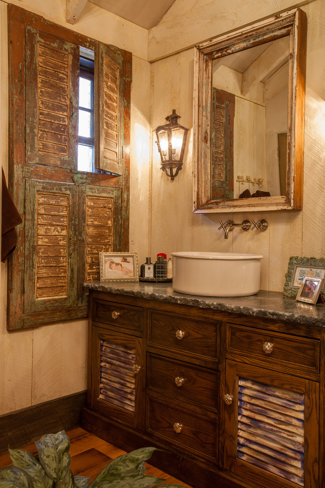 Идея дизайна: ванная комната в стиле рустика с настольной раковиной, искусственно-состаренными фасадами и фасадами с филенкой типа жалюзи
