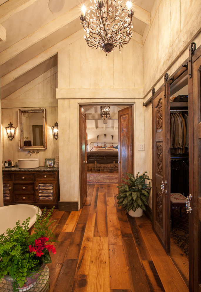 Inspiration for a rustic freestanding bathtub remodel in Dallas with a vessel sink, distressed cabinets and louvered cabinets