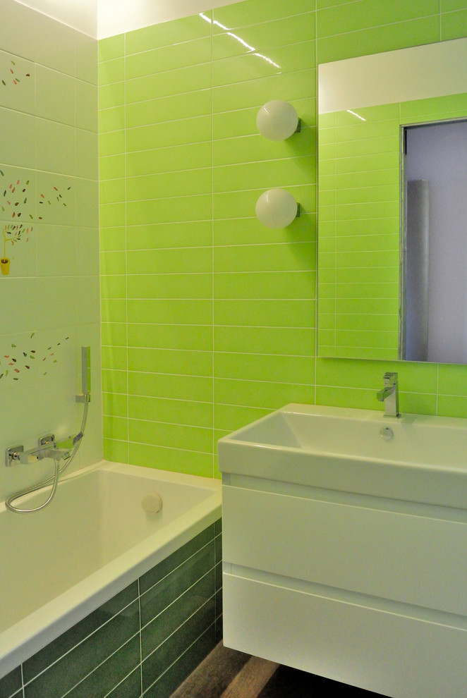 Foto di una stanza da bagno padronale minimal di medie dimensioni con WC sospeso, piastrelle in ceramica, lavabo sospeso, vasca da incasso, piastrelle verdi, pareti verdi e parquet scuro