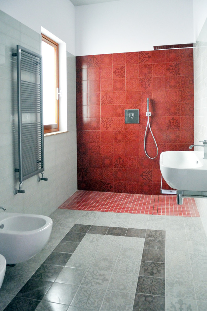 Immagine di una stanza da bagno con doccia contemporanea di medie dimensioni con doccia a filo pavimento, WC sospeso, piastrelle grigie, piastrelle in ceramica, pareti grigie, pavimento in gres porcellanato e lavabo sospeso