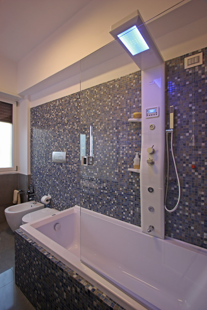 Inspiration för ett stort funkis en-suite badrum, med ett platsbyggt badkar, en dusch/badkar-kombination, en vägghängd toalettstol, blå kakel, mosaik, blå väggar och klinkergolv i keramik